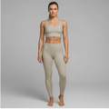 A model showcases the full DuelStars Core Femme sportswear set in stone grey, featuring the high-waisted leggings and matching sports bra with floral detailing.