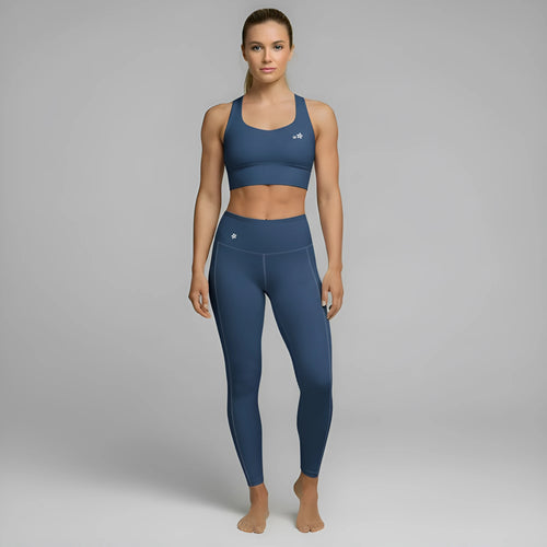 A model showcases the full DuelStars Core Femme sportswear set in ocean blue, featuring the high-waisted leggings and matching sports bra with floral detailing. [cw:ocean-blue]