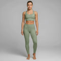 A model showcases the full DuelStars Core Femme sportswear set in sage green, featuring the high-waisted leggings and matching sports bra with floral detailing.